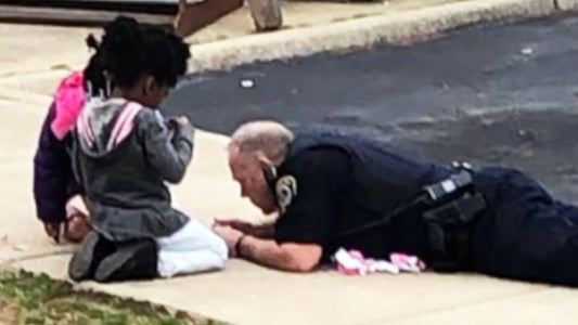 Police officer plays with dolls in his community and it's adorable